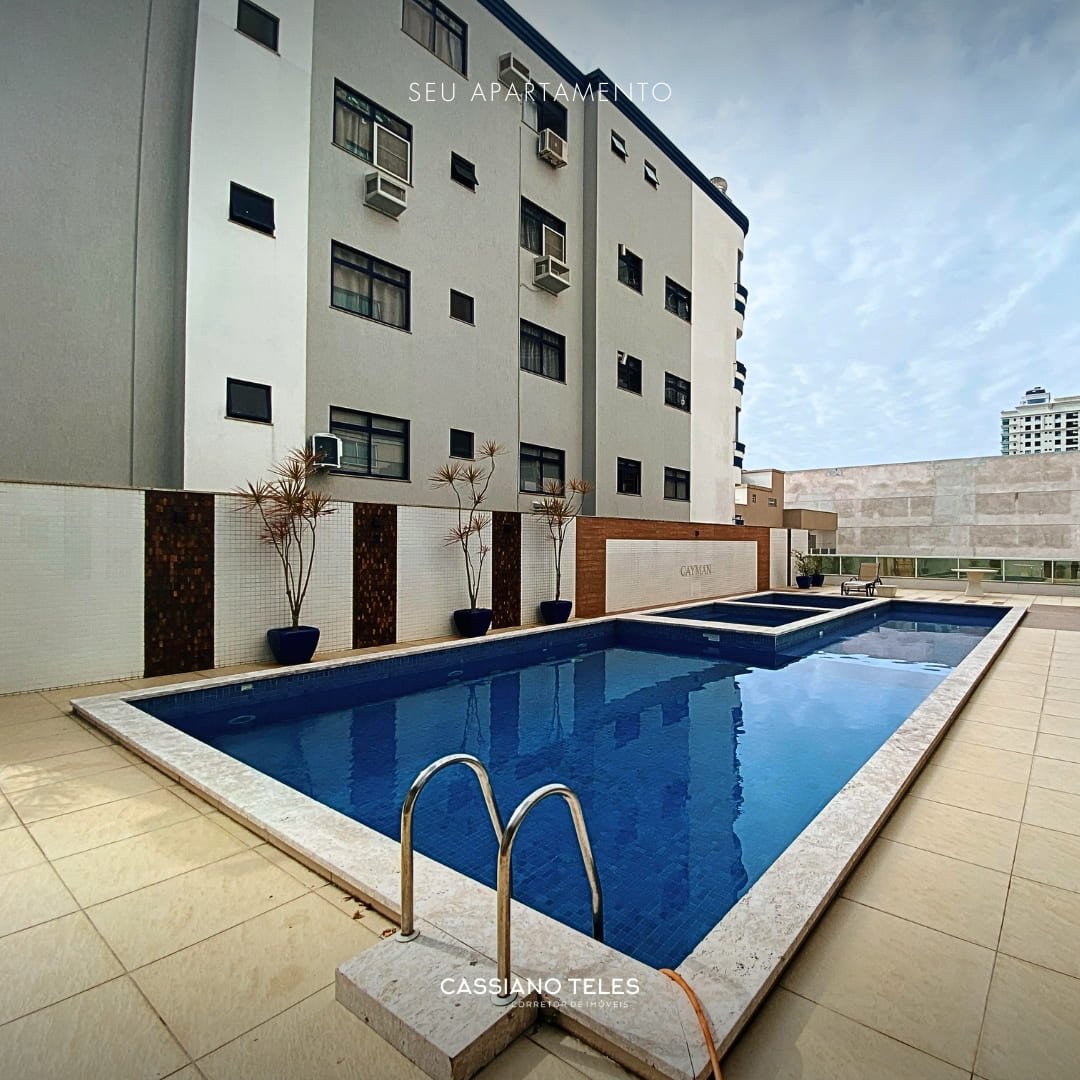 Área externa da piscina com espaço de descanso no Residencial Cayman em Itapema.